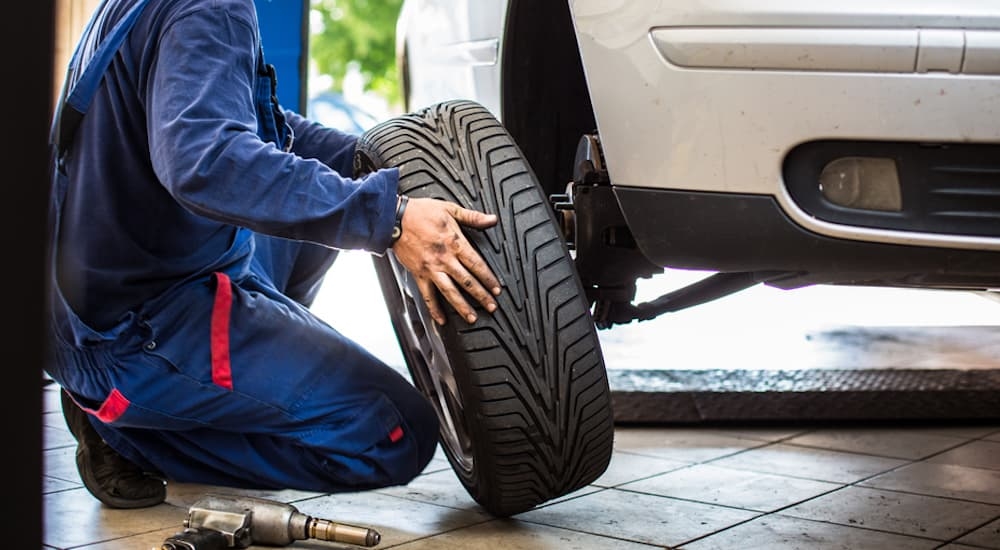 A mechanic putting a tire on a car at a Honda service center near me.