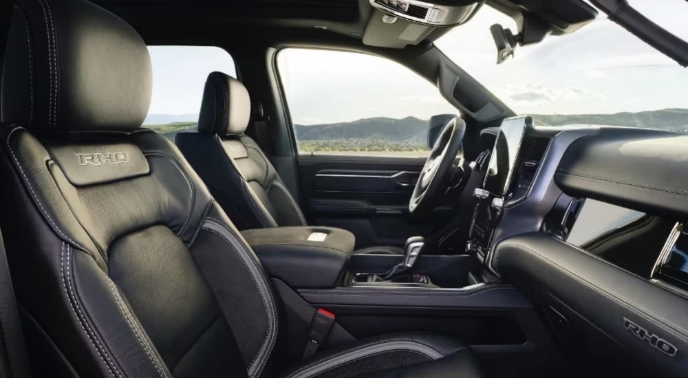 The black leather interior is shown in a 2025 Ram 1500 RHO.