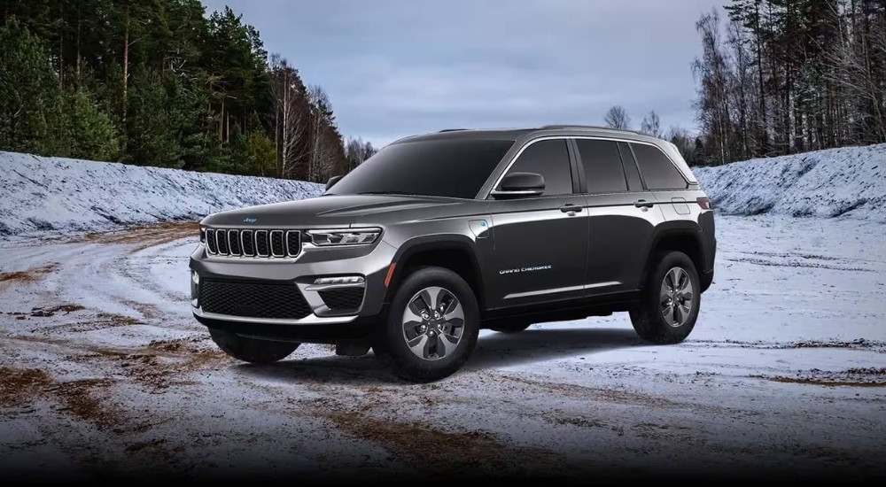 A grey 2024 Jeep Grand Cherokee 4xe is shown parked on a snow-covered lot.