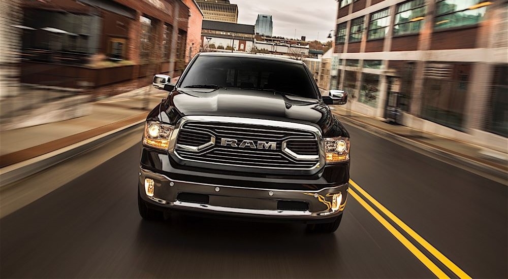 A black 2016 Ram 1500 is shown driving to a used Ram dealership.