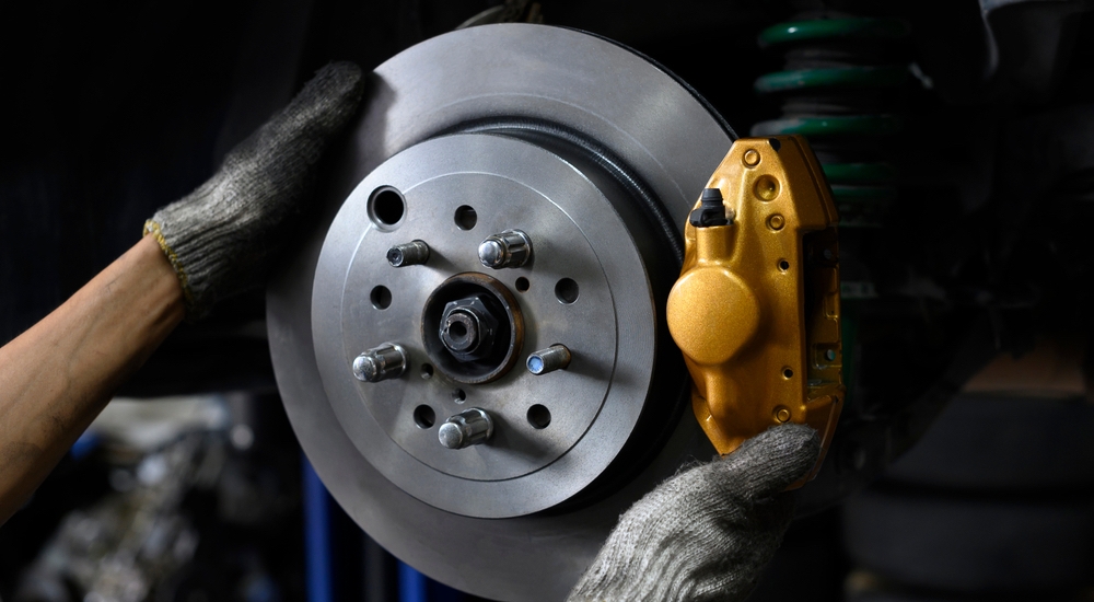 A mechanic interacting with a brake disc during a Honda service near me.