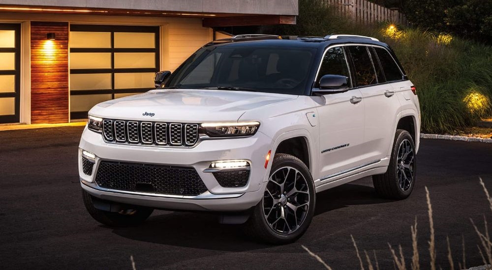 A white 2024 Jeep Grand Cherokee 4xe is shown parked on a driveway after leaving a Jeep dealer near Red Hook.