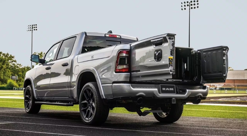 A tan 2023 Ram 1500 Laramie is shown near a football field.