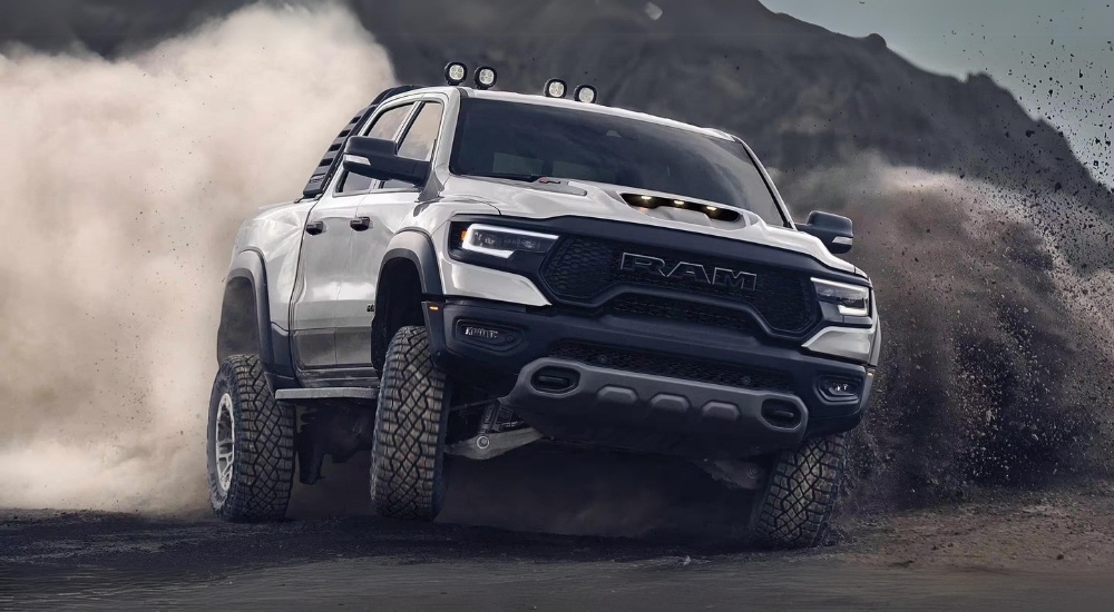 A silver 2023 Ram 1500 TRX is shown kicking up dust after leaving a Ram dealer near Red Hook.