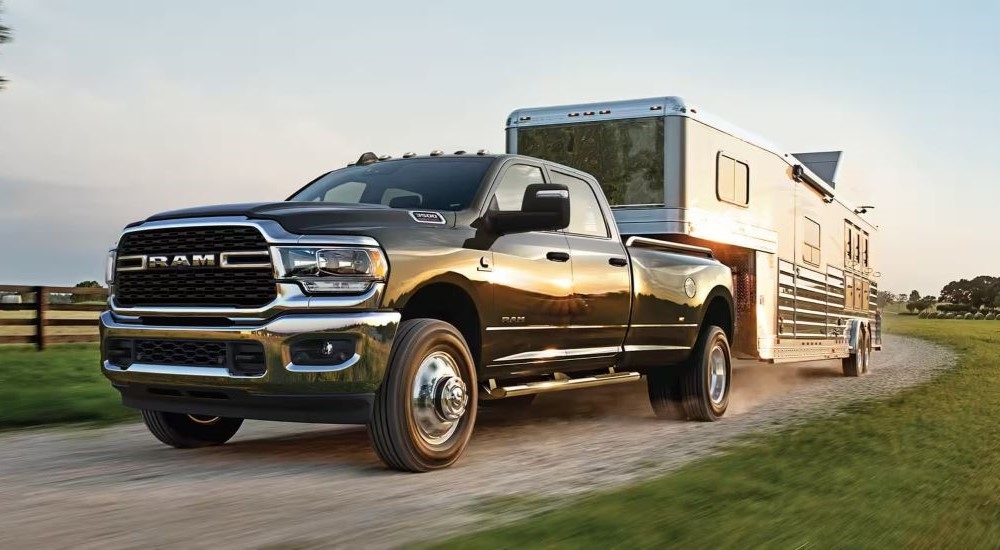 A black 2023 Ram 3500 for sale is shown towing a trailer.