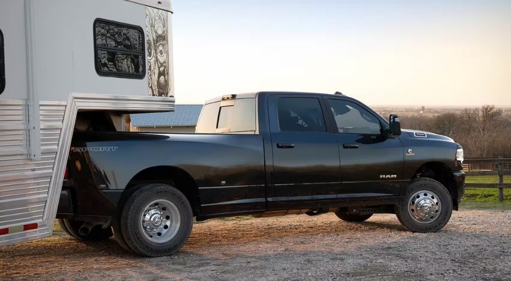 A black 2023 Ram 3500 Sport is shown parked near a fence.