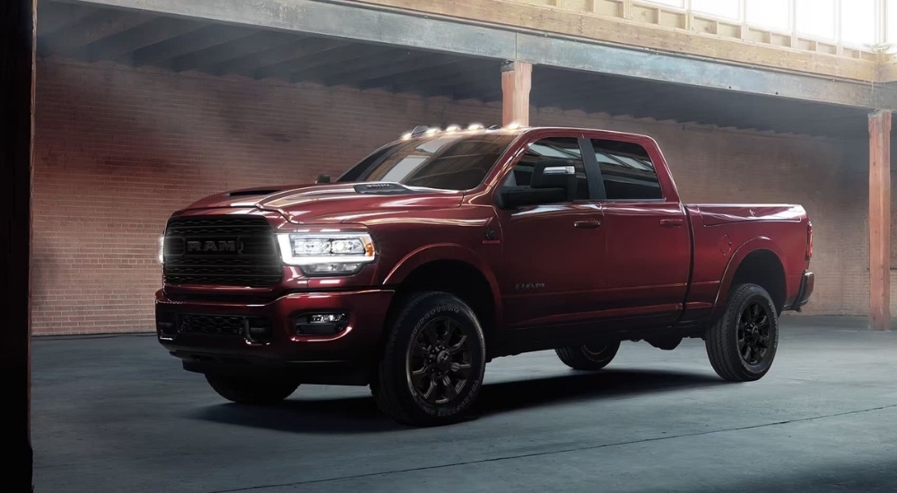 A red 2024 Ram 2500 for sale is shown parked in a warehouse.