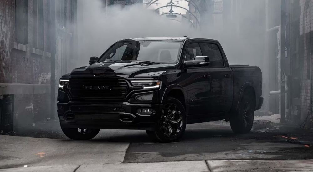 A black 2024 Ram 1500 for sale is shown parked in an alleyway.