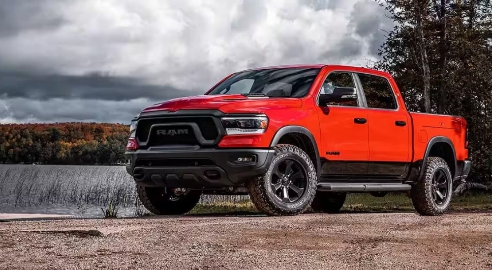 A red 2024 Ram 1500 for sale is shown parked near a lake.