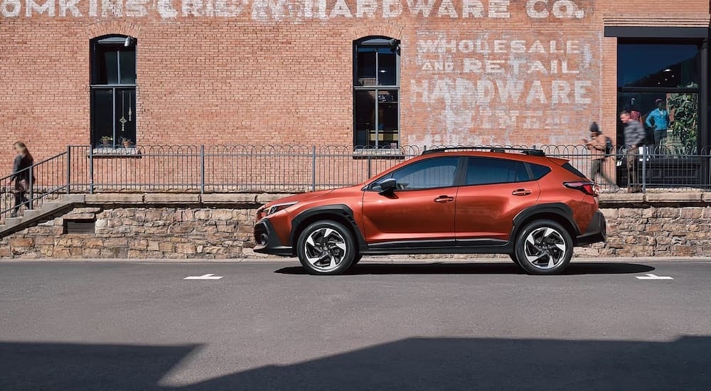 An orange 2024 Subaru Crosstrek Limited is shown from the side after leaving a dealer that has a Subaru Crosstrek for sale in Rhinebeck.