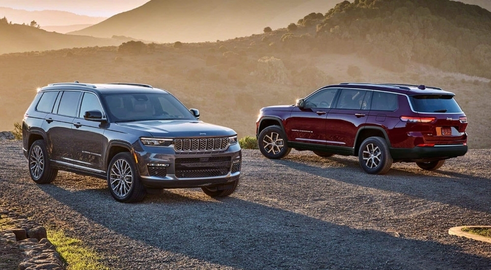 A grey 2024 Jeep Grand Cherokee and red Grand Cherokee L are shown parked off-road.