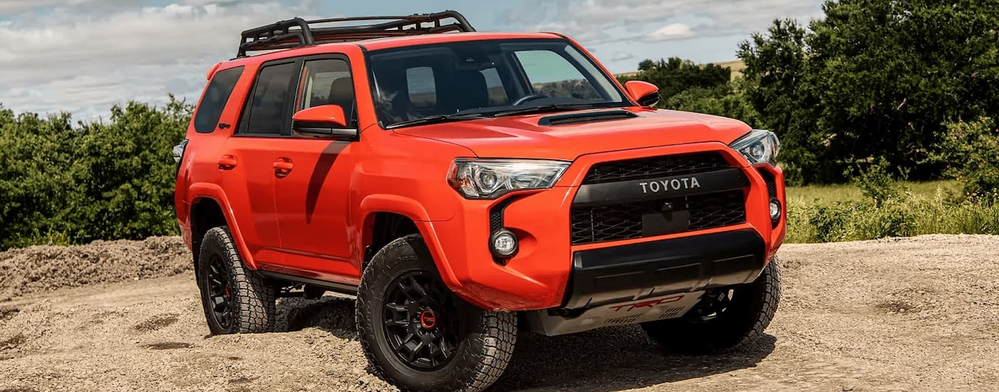 An orange 2024 Toyota 4Runner TRD Pro parked off-road and angled right.