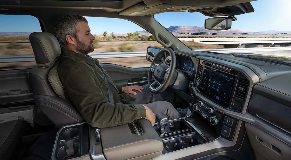 A man using BlueCruise while sitting inside a 2024 Ford F-150 XLT.