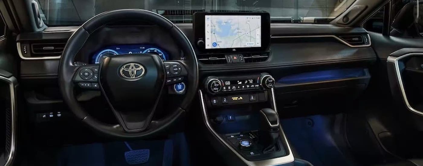 The black interior of a 2024 Toyota RAV4 is shown from teh driver's seat.