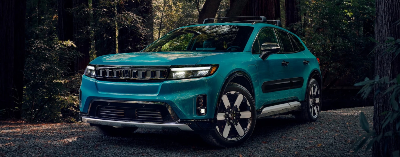 A blue 2024 Honda Prologue Elite parked in the woods.