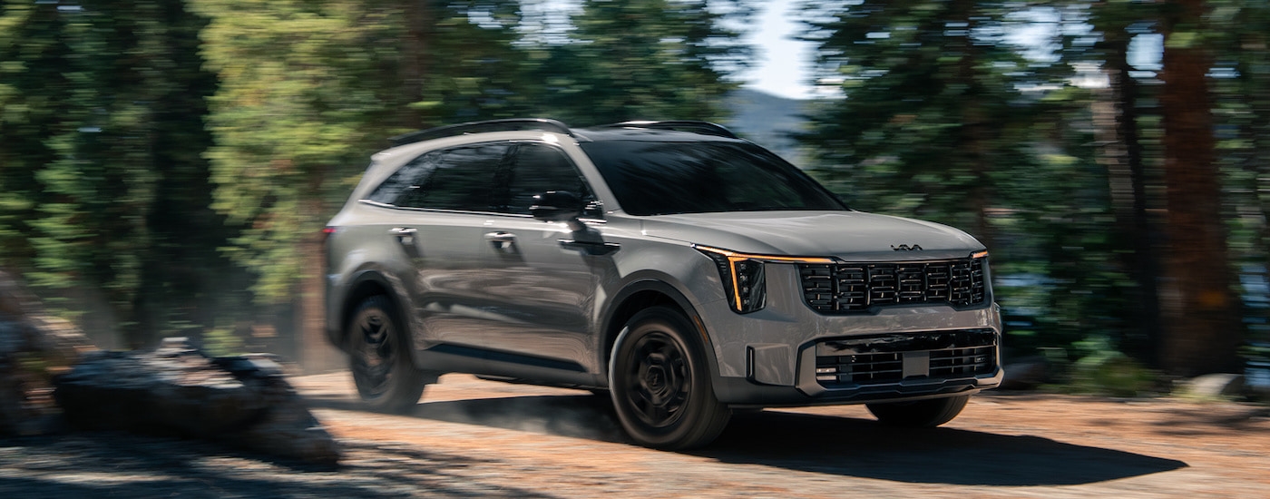 A grey 2024 Kia Sorento is shown from the front at an angle after leaving a dealer that has SUVs for sale.