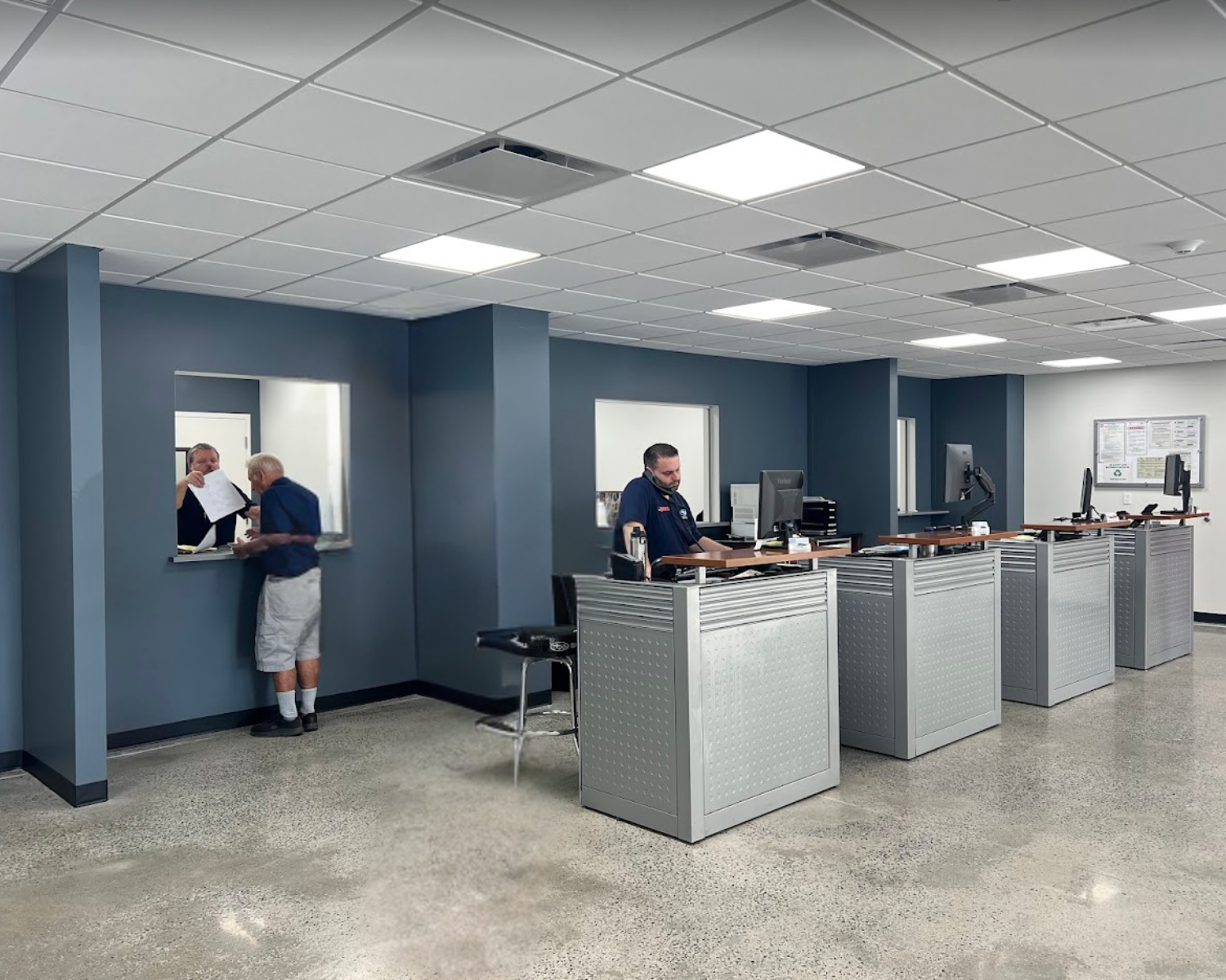 Customer representatives standing in their booths at a Subaru dealership in Rhinebeck