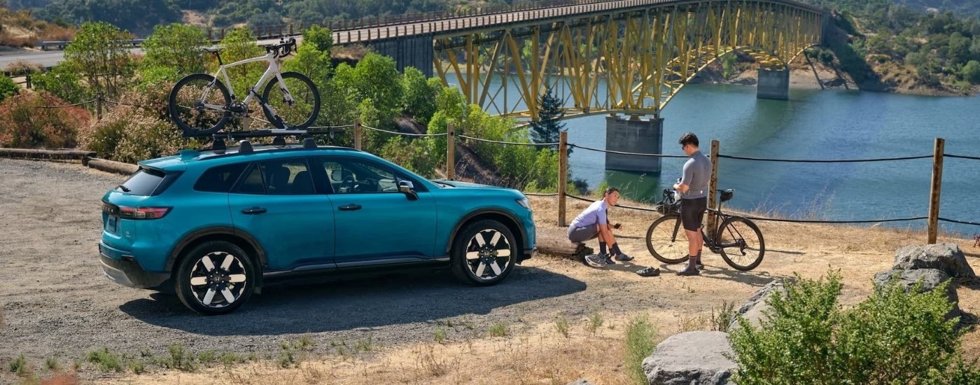 A teal 2024 Honda Prologue Elite is shown near a river.