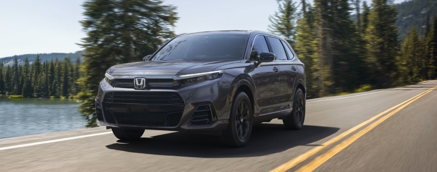 A grey 2025 Honda CR-V eFCEV is shown driving to a Honda dealer near Edmonds.