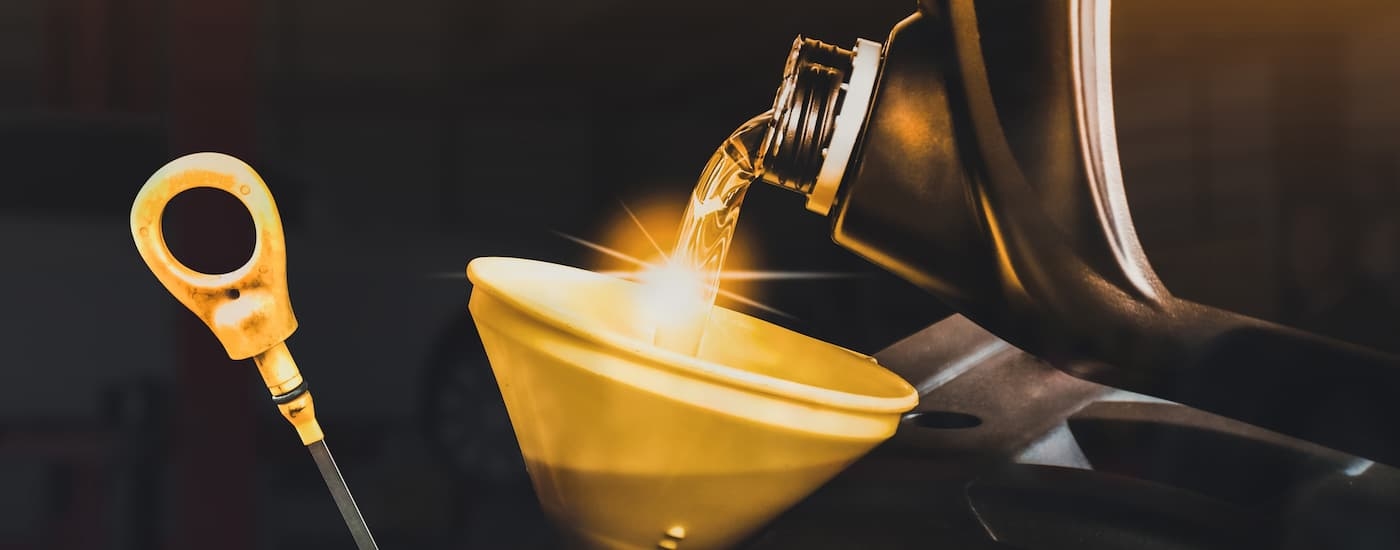 Close-up of an oil can being poured into a funnel.