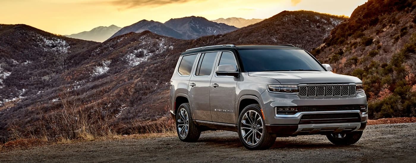 A grey 2023 Jeep Grand Wagoneer L parked off-road and angled right.