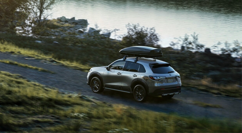 A silver 2024 used Honda HR-V for sale driving on a dirt trail.