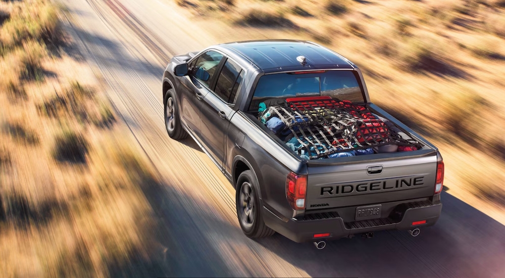 Overhead view of a silver 2025 Honda Ridgeline RTL driving on a dirt road.