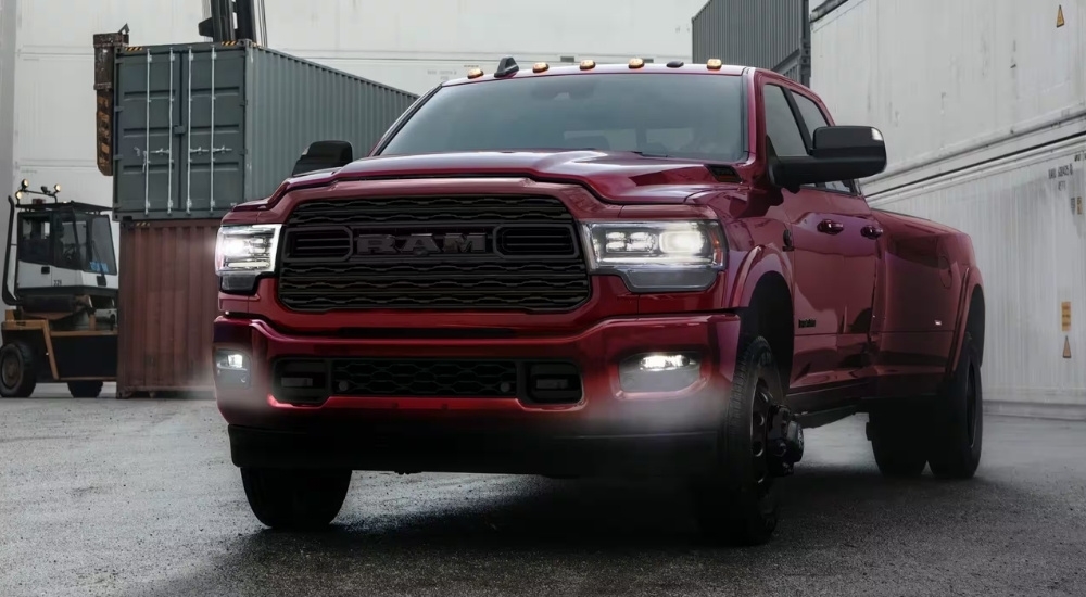 A red 2021 Ram 3500 is shown near shipping containers.