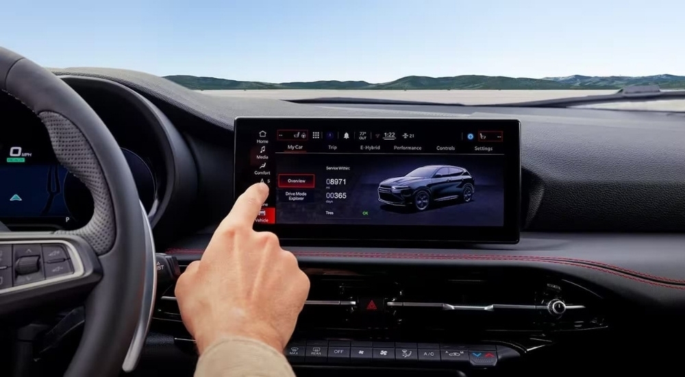 A person is shown using the infotainment screen in a 2023 Dodge Hornet.