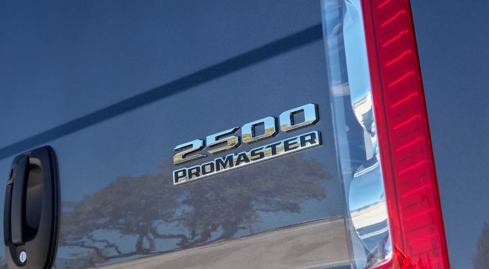 A close up shows a chrome badge on a grey 2023 Ram Promaster 2500.