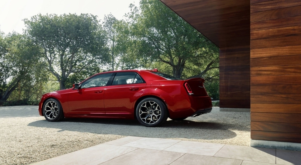 A red 2015 Chrysler 300 S is shown parked on a gravel driveway.