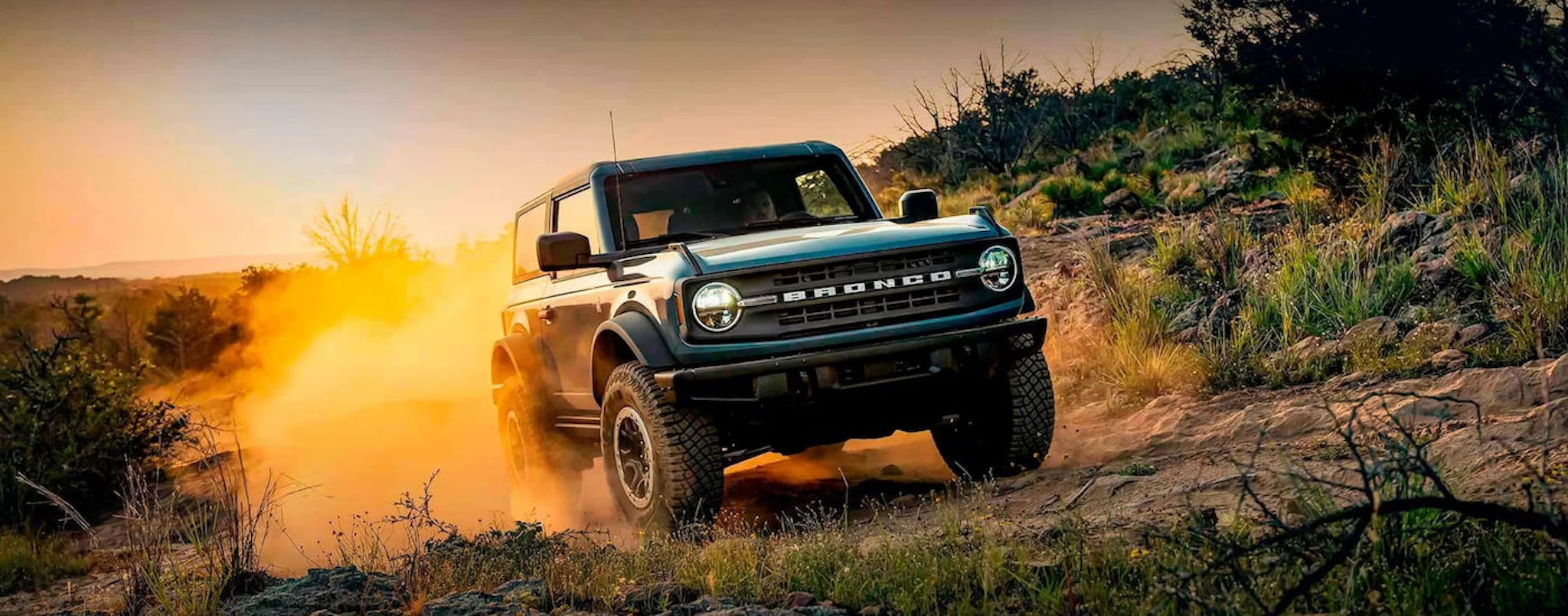 A teal 2024 Ford Bronco Black Diamond off-roading on a dusty trail.