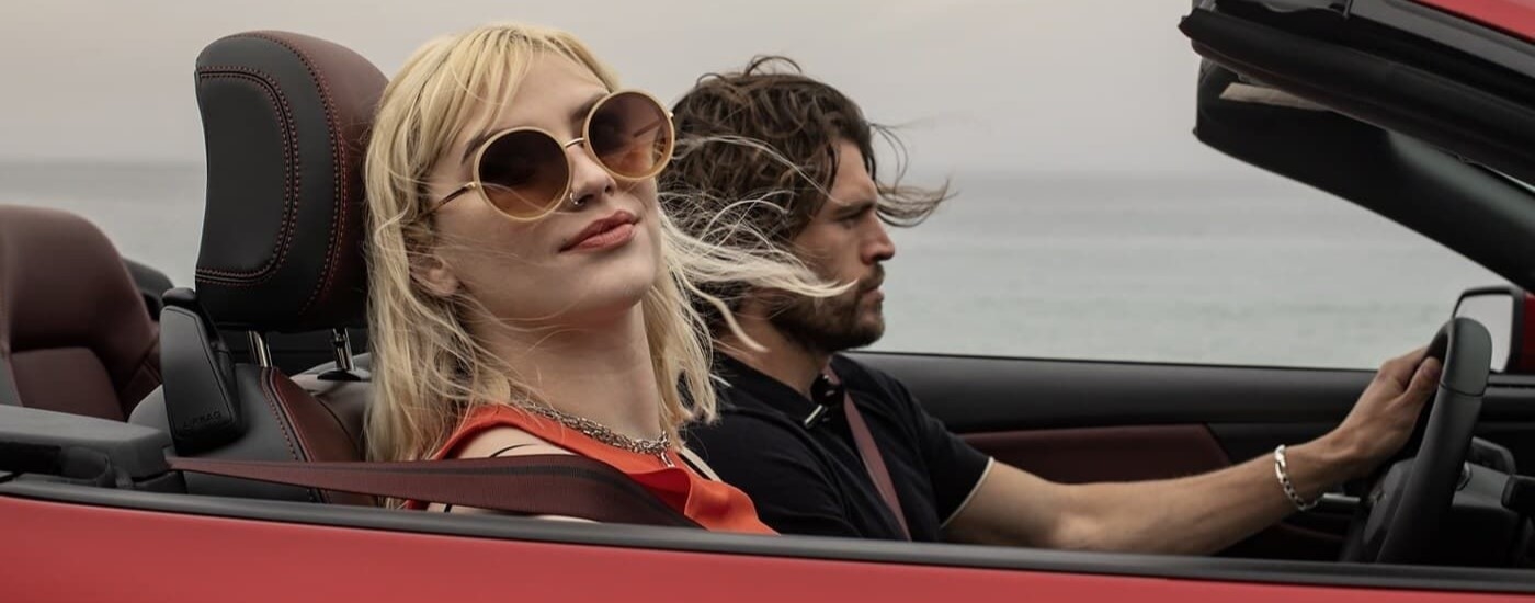 People are shown riding in a red 2024 Ford Mustang.