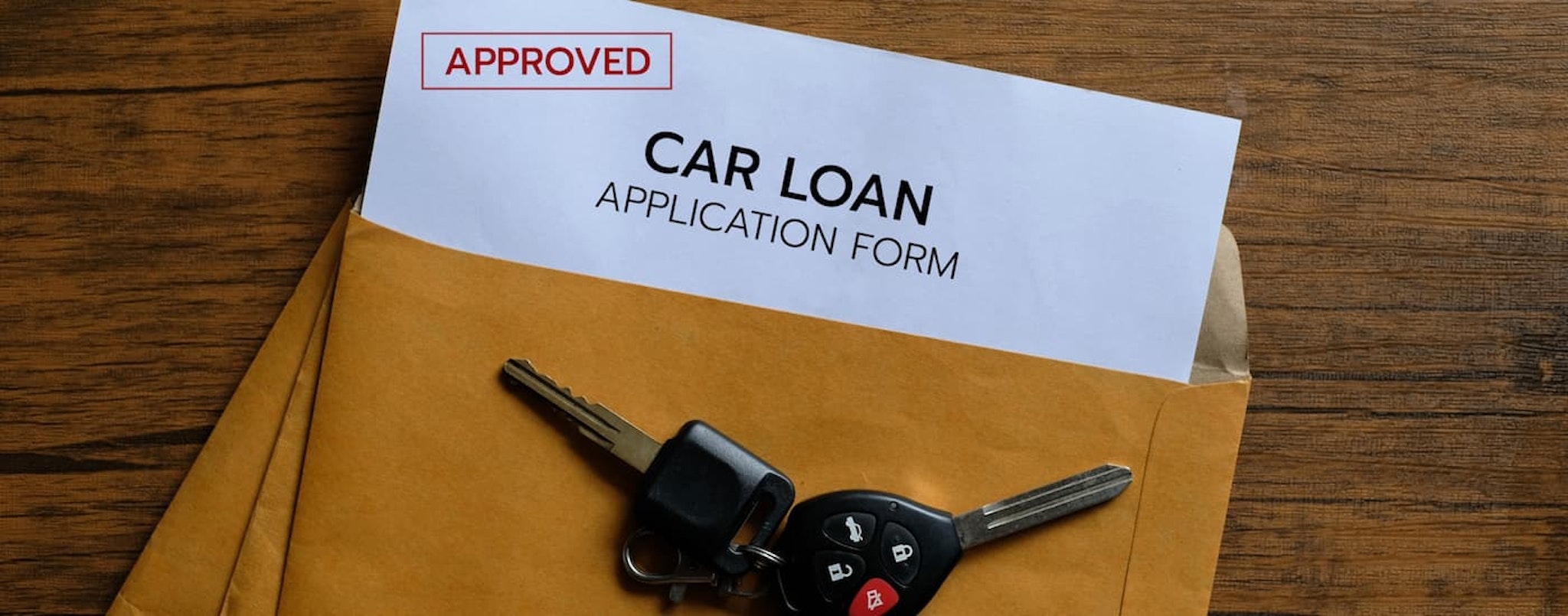 An orange envelope is shown with a subprime auto loan application near Brattleboro, VT.