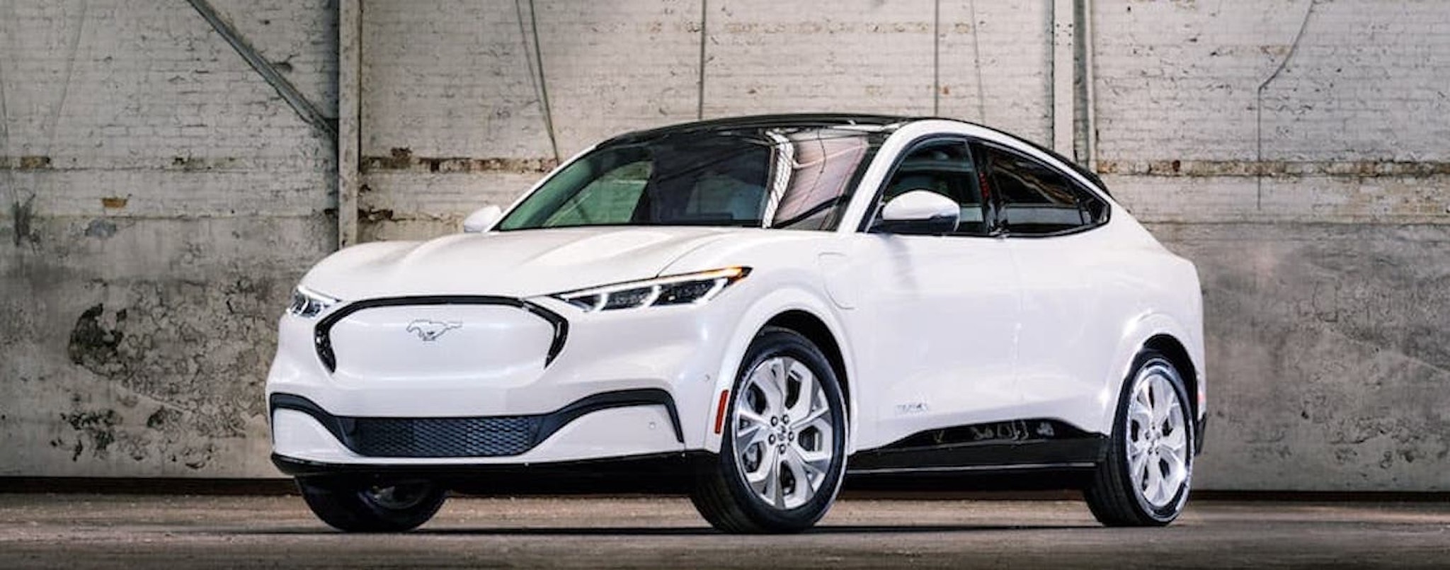 A white 2022 Ford Mustang Mach-E is shown from the front at an angle after leaving a Ford EV dealer.