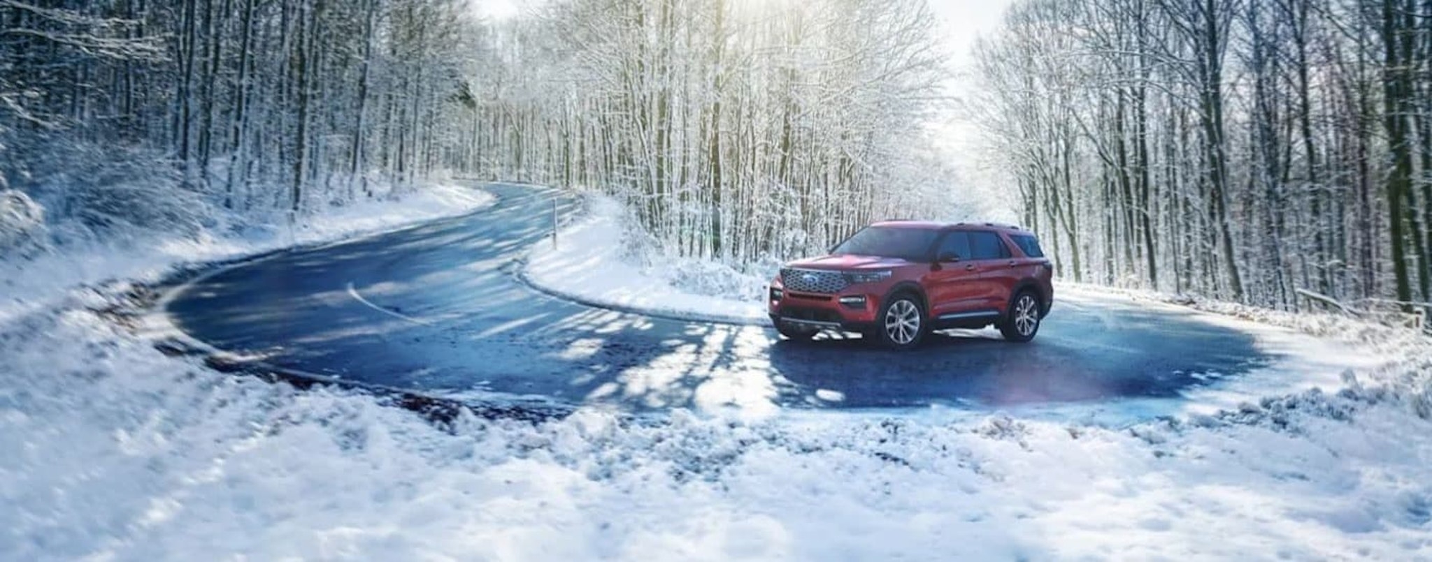 A red 2022 Ford Explorer for sale is shown rounding a snowy corner.