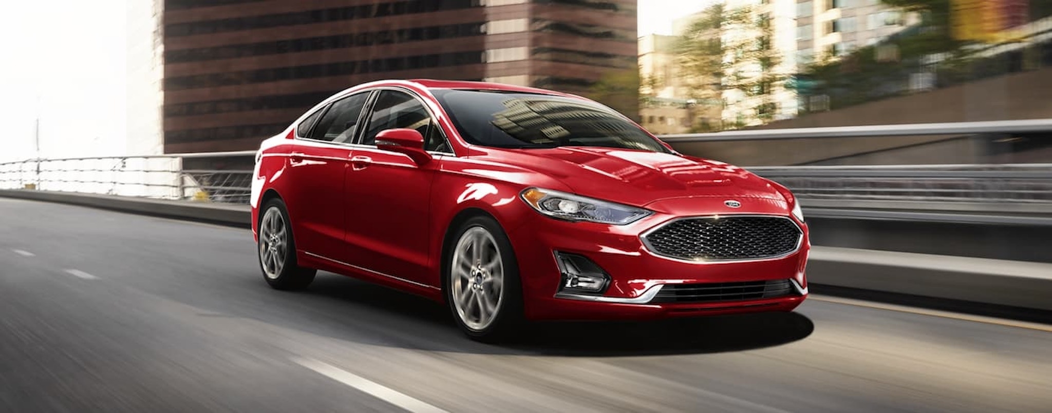 A red 2020 Ford Fusion is shown driving on a ramp.