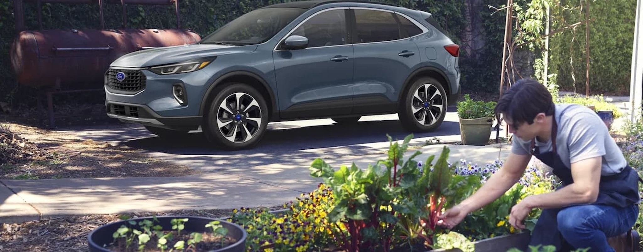 A grey 2023 Ford Escape is shown from the side parked in a driveway after visiting a Ford SUV dealer.