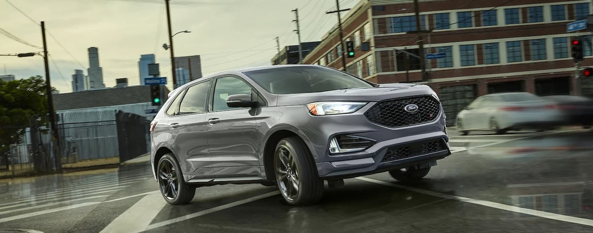 A grey 2022 Ford Edge ST is shown turning on a city street.