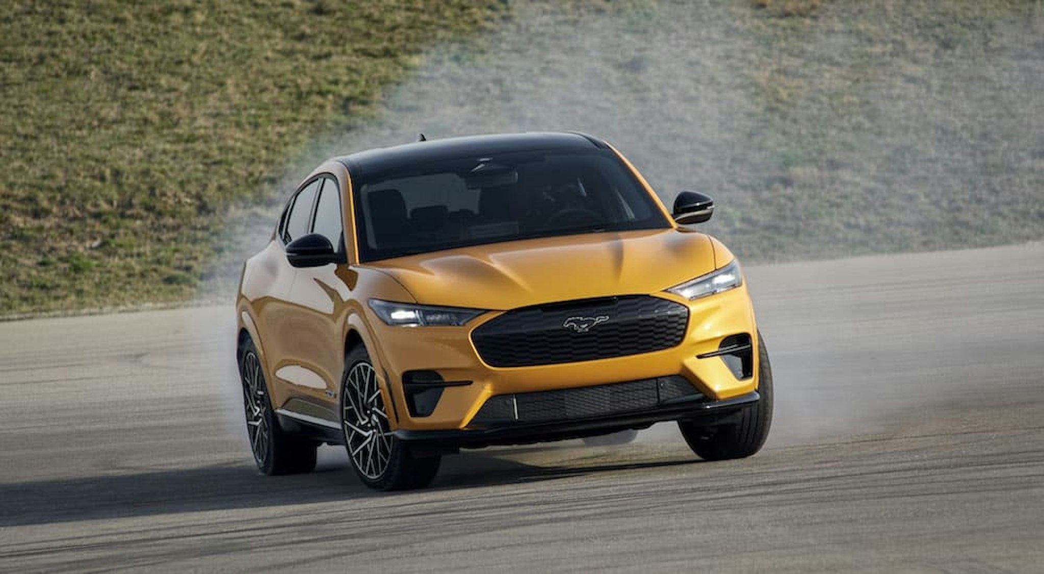 A yellow 2021 Ford Mustang Mach-E GT is shown from the front at an angle after leaving a Ford EV dealer.