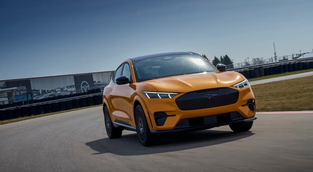 A yellow 2023 Ford Mustang Mach-E GT is shown from the front at an angle after leaving a Ford EV dealer.