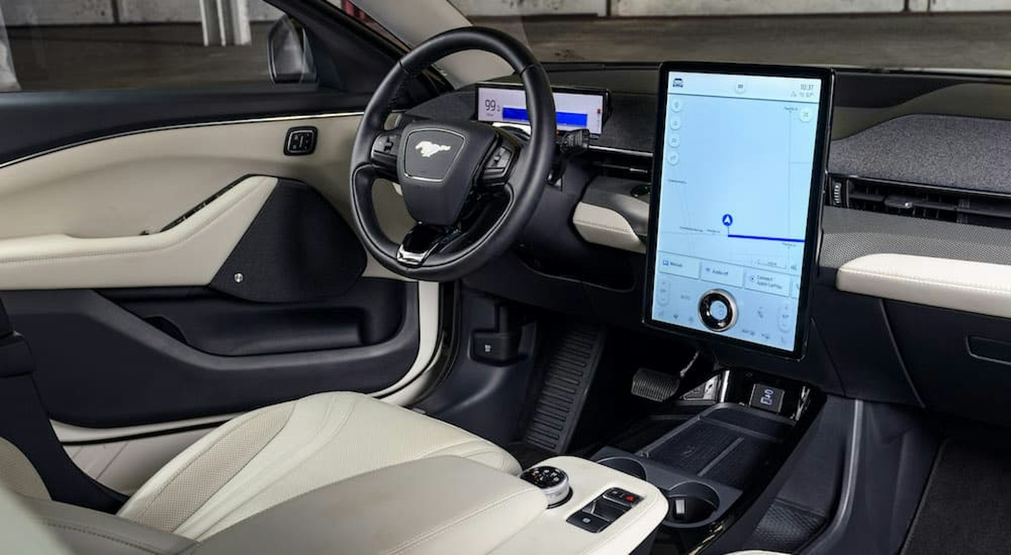 The white and black interior of a 2023 Ford Mustang Mach-E is shown from the passenger side.