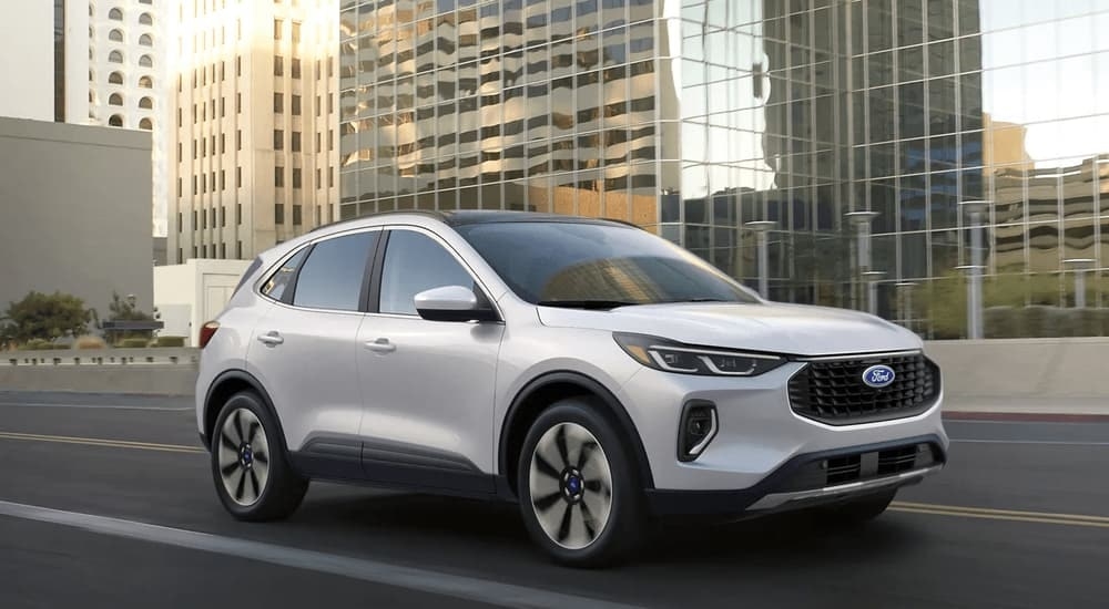 A white 2023 Ford Escape is shown driving on a city highway.