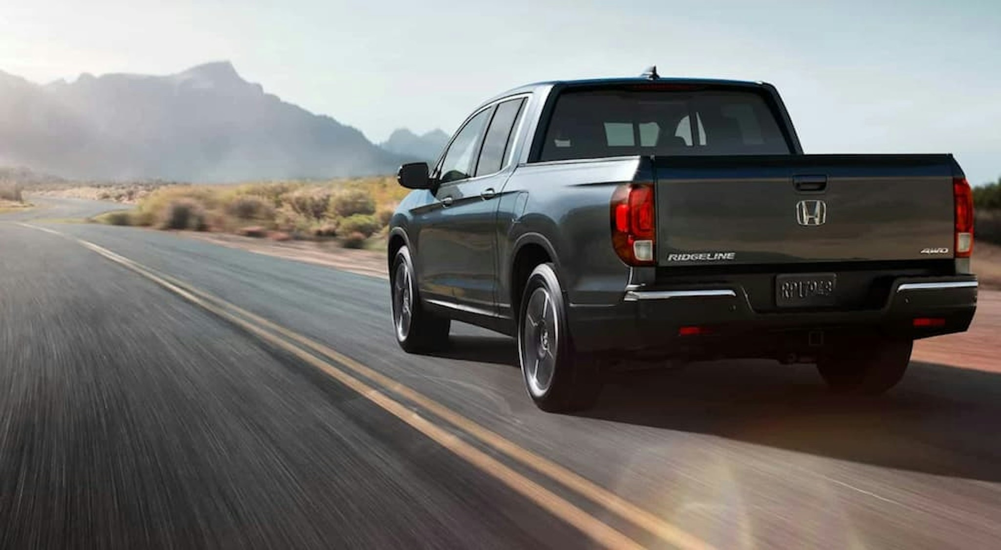 A grey 2020 Honda Ridgeline is shown from the rear at an angle.