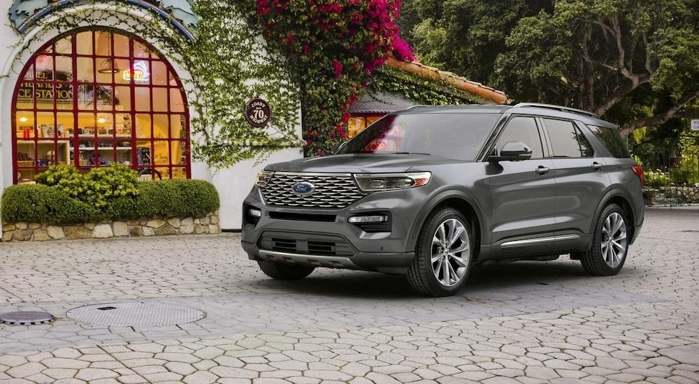 A silver 2023 Ford Explorer Platinum parked in an open courtyard.