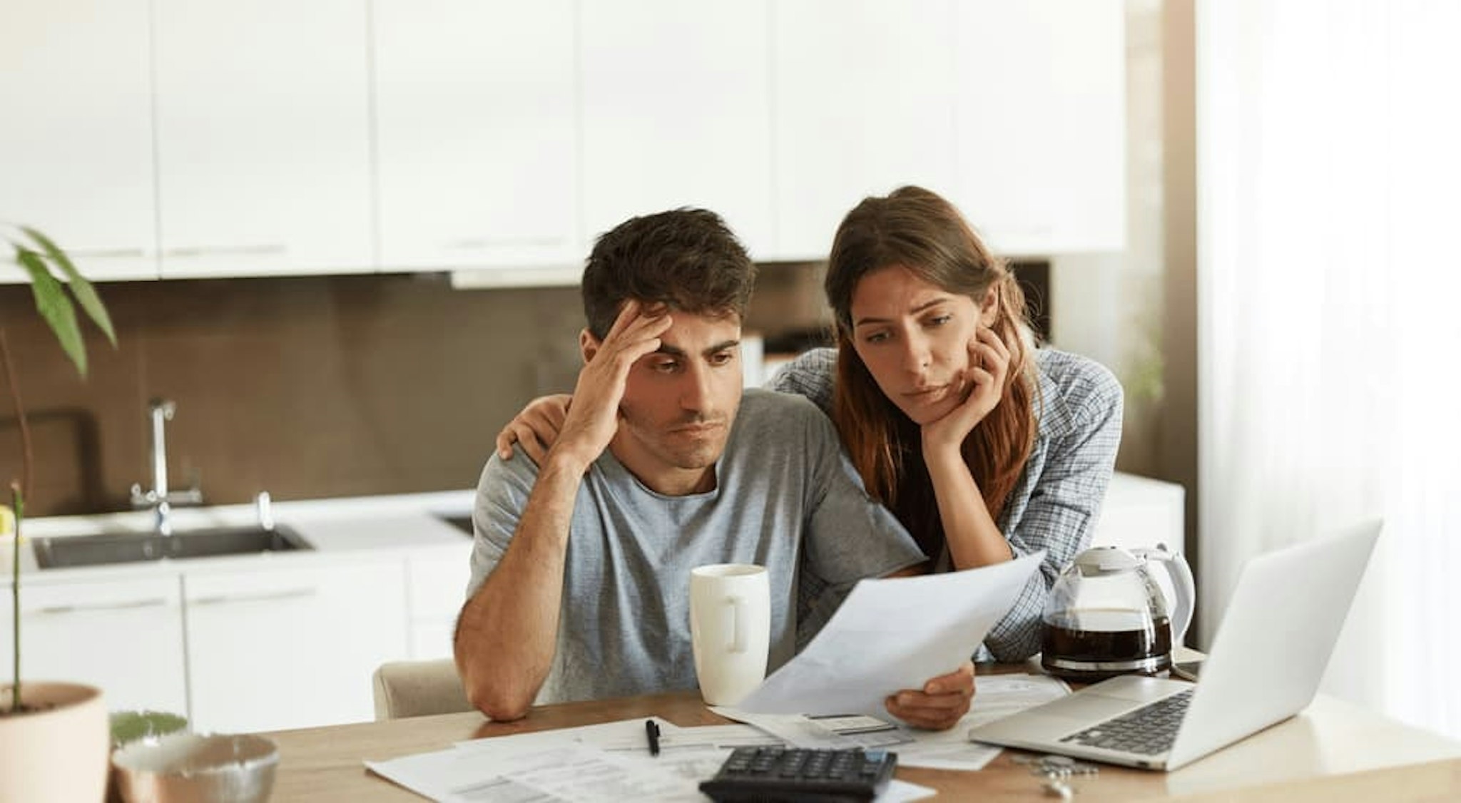 A couple are shown going over paperwork while looking at subprime auto loans near Brattleboro, VT.