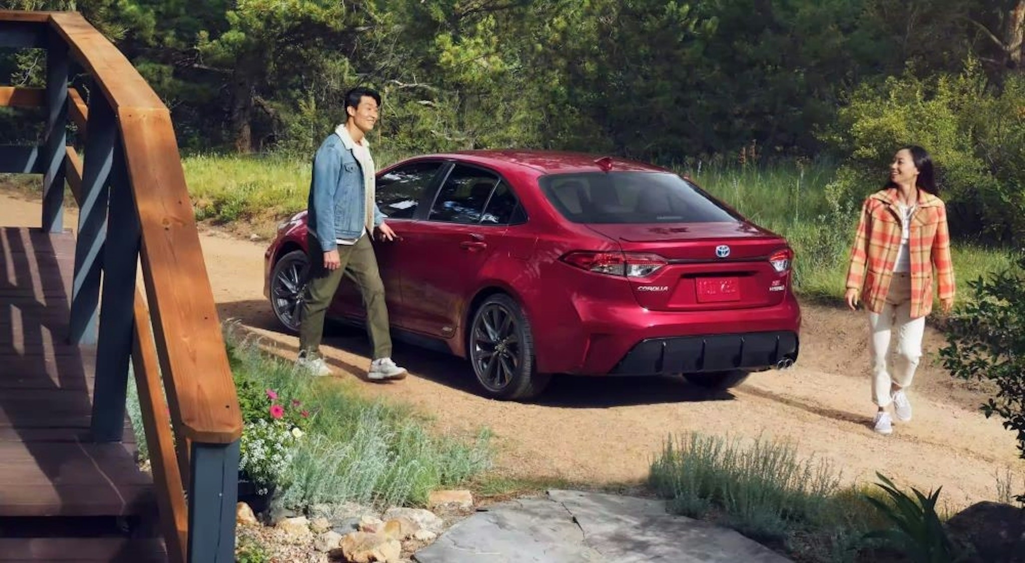 A red 2023 Toyota Corolla Hybrid SE is shown on a dirt path.