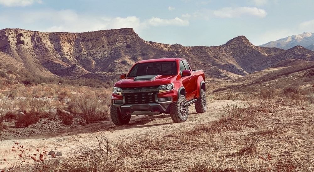 One of the most popular used Chevy trucks for sale, a red 2021 Chevy Colorado ZR2, is shown off-road.