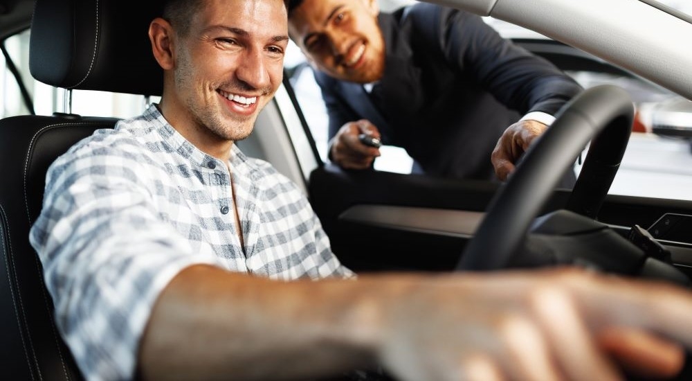 A smiling person is shopping at a dealer providing bad credit car loans near Newport, NH