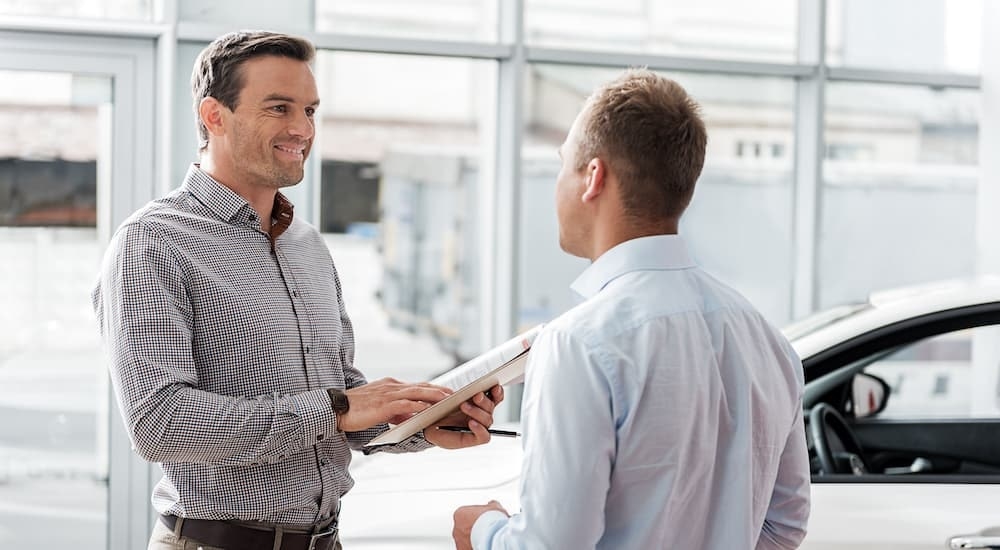 Someone is shown discussing a bad credit car loan near Bennington with a salesman.